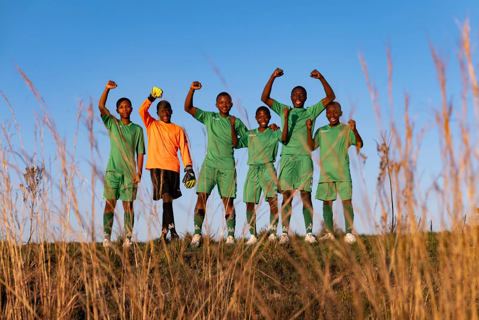 Young football team celebrating, Kappa campaign photography